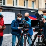 촬영현장의 문제 해결 경험담 - A professional film set during daytime in a French urban environment, showcasing a flexible shooting...